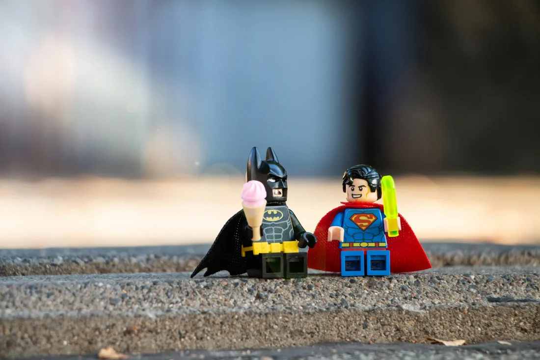 LEGO® Batman and Superman minifigures sitting together