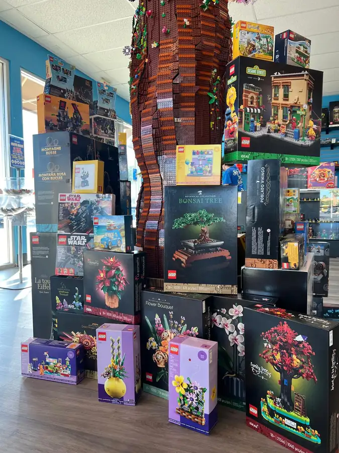 A second view of boxed LEGO® sets stacked around the Henderson store tree.
