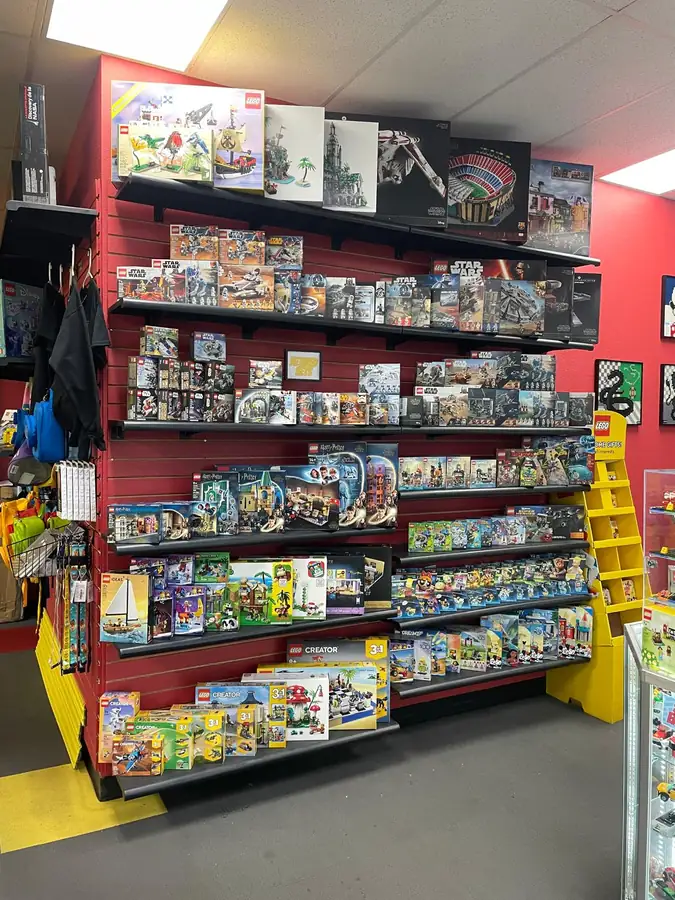Shelves of boxed LEGO® sets against the red and yellow store walls.