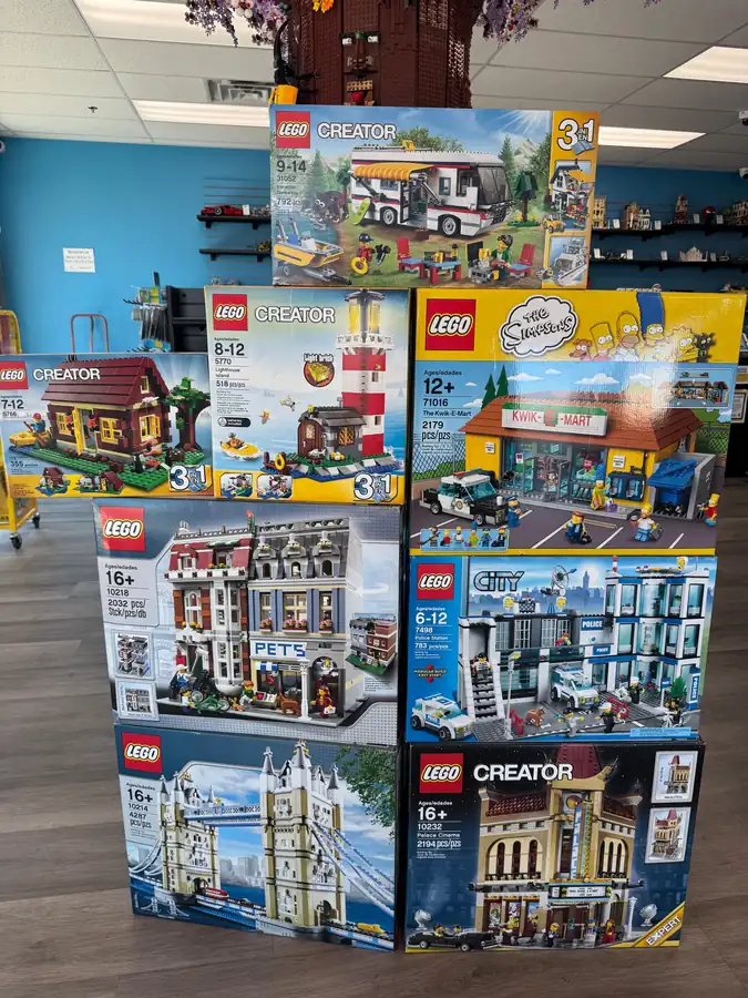 A stack of boxed LEGO® sets beside glass display cabinets at Henderson.