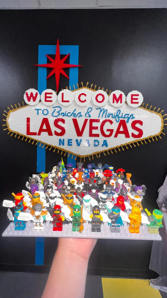 An assortment of LEGO® minifigures on a display board beneath the Las Vegas store sign.