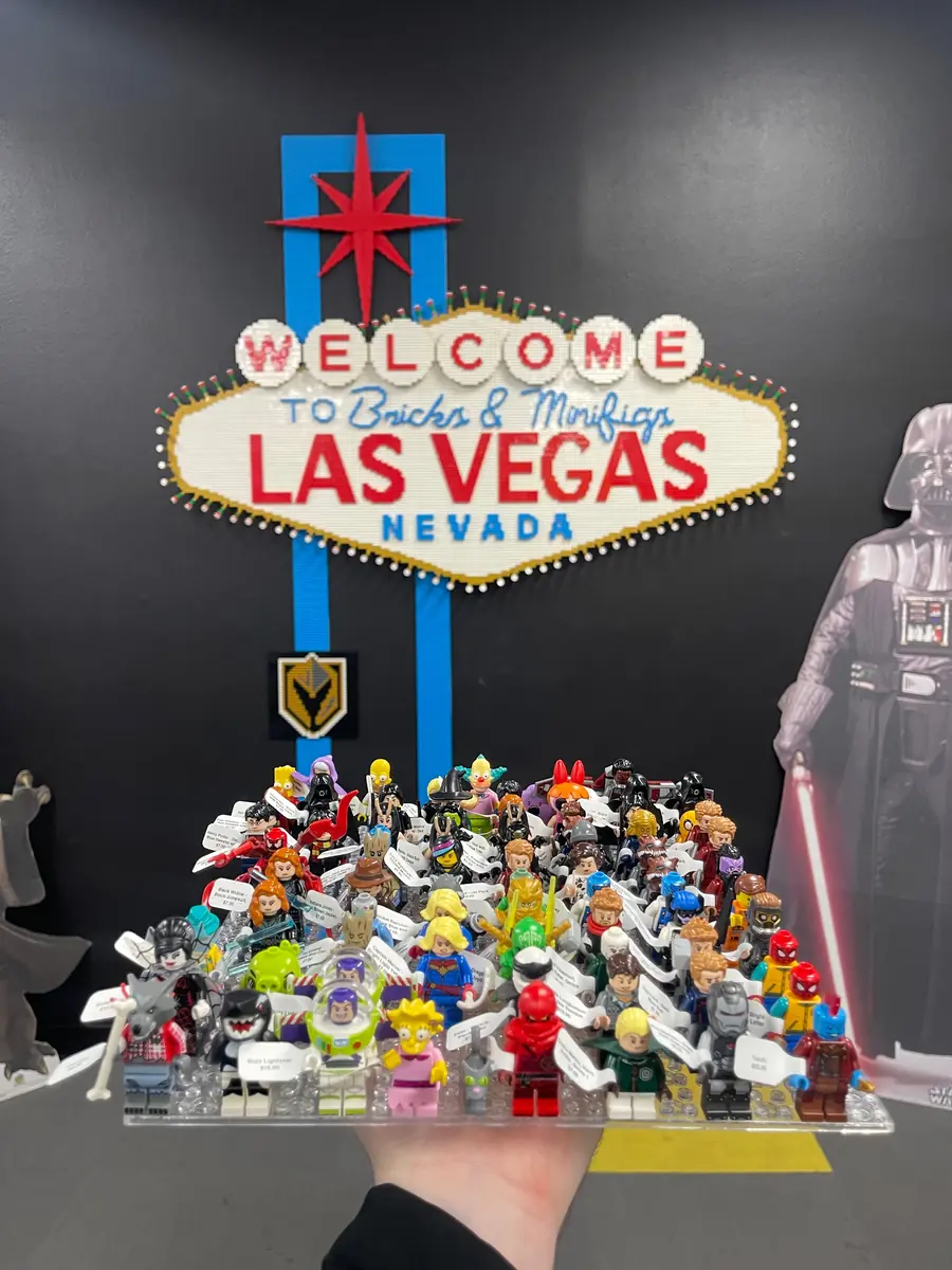 An assortment of LEGO® minifigures on a display board beneath the Las Vegas store sign.