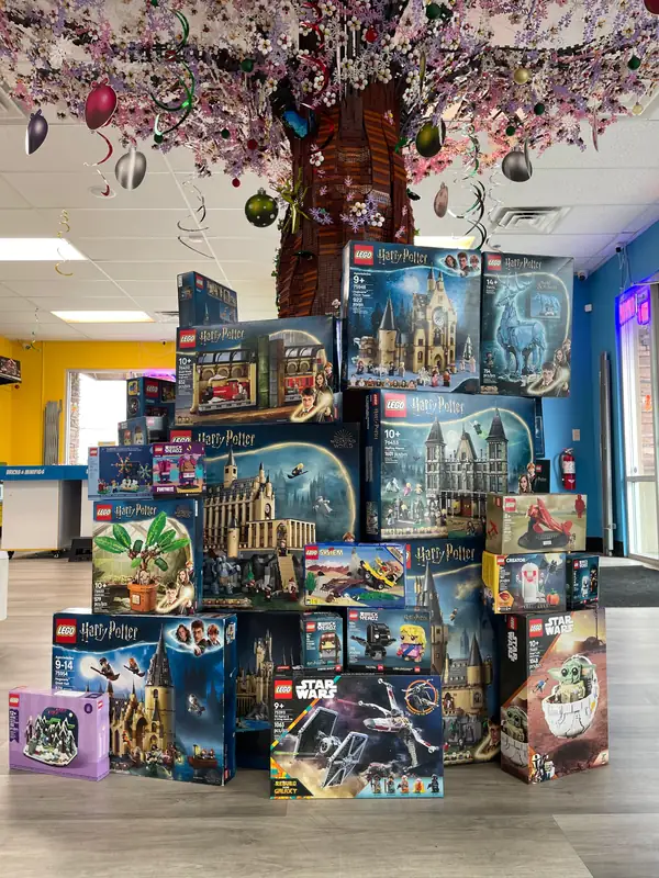 Boxed LEGO® sets stacked beneath the decorated tree for the holiday restock.