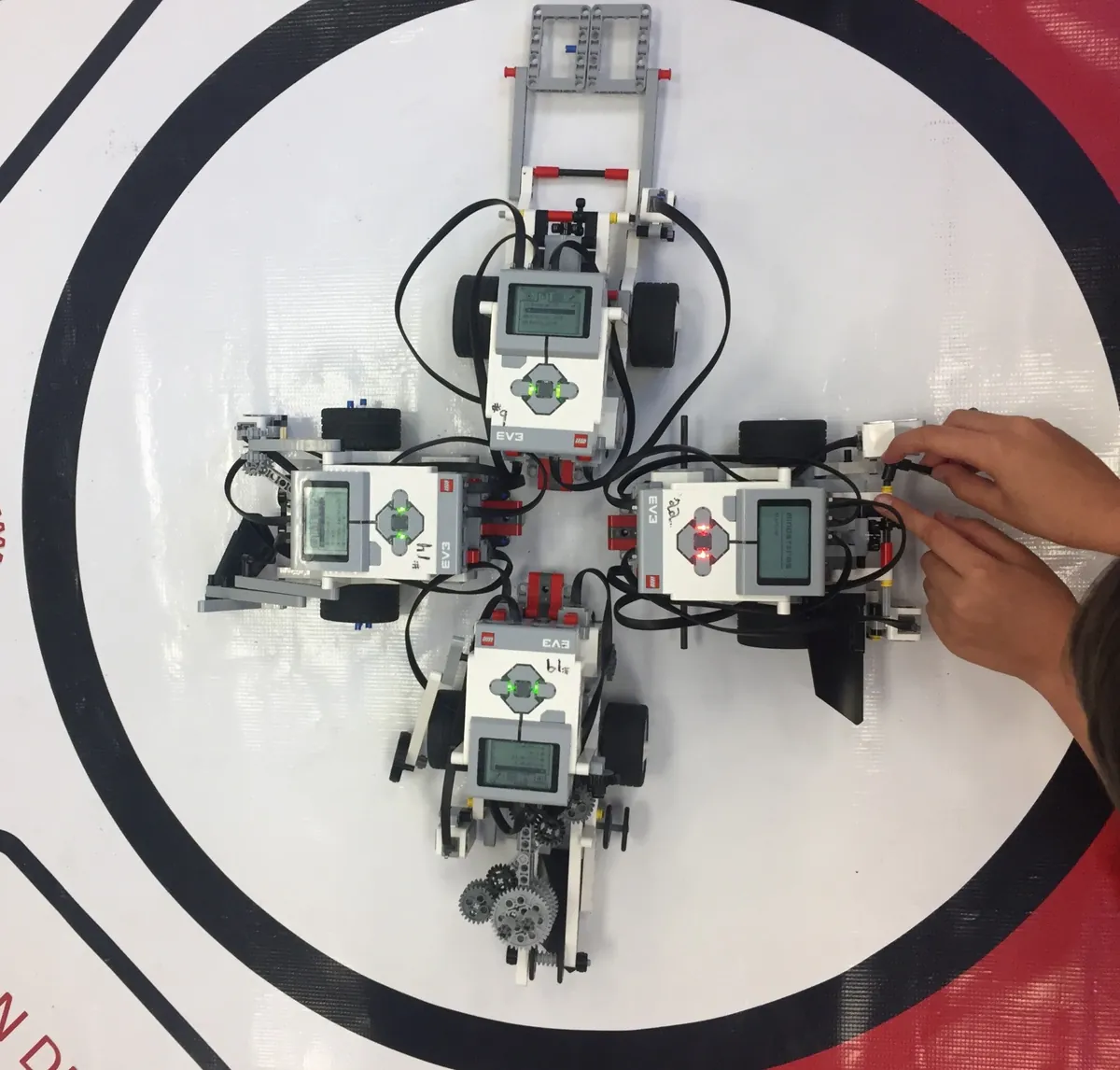 Four programmable LEGO® robots positioned together in a circular sumo arena.