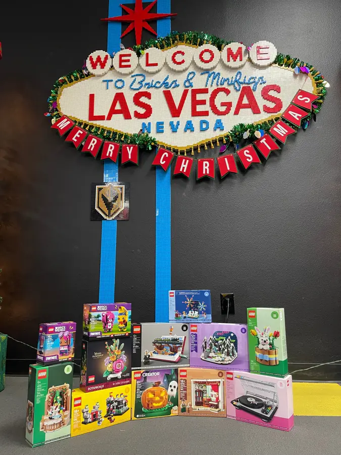 Small boxed LEGO® sets displayed beneath the Las Vegas sign and holiday garland.