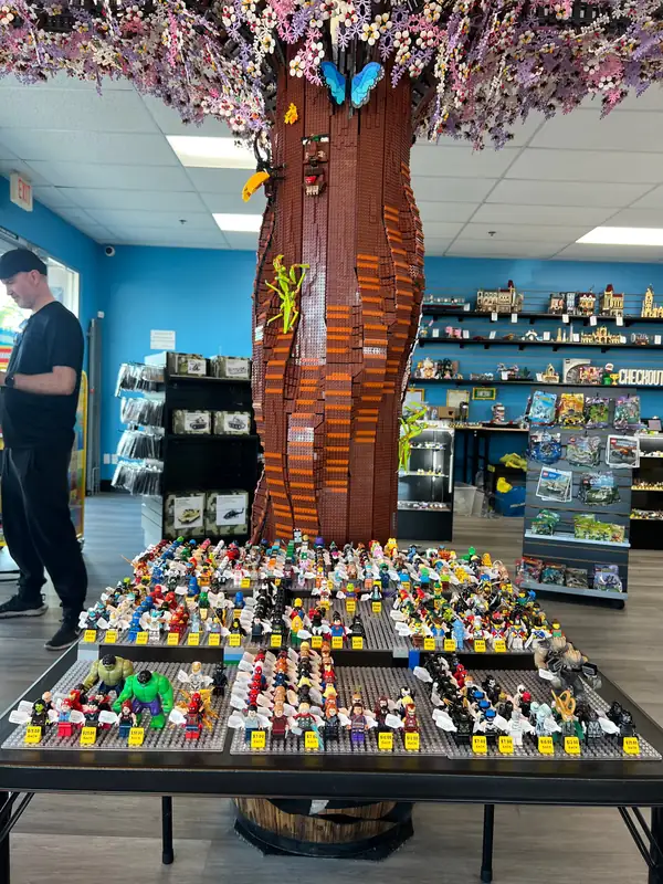Rows of LEGO® minifigures covering a table beneath the Henderson store tree.