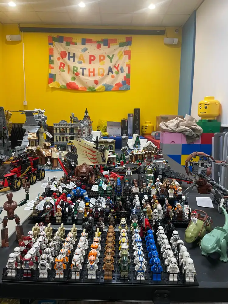 A wider view of the minifigure and assembled-model display beneath a birthday banner.