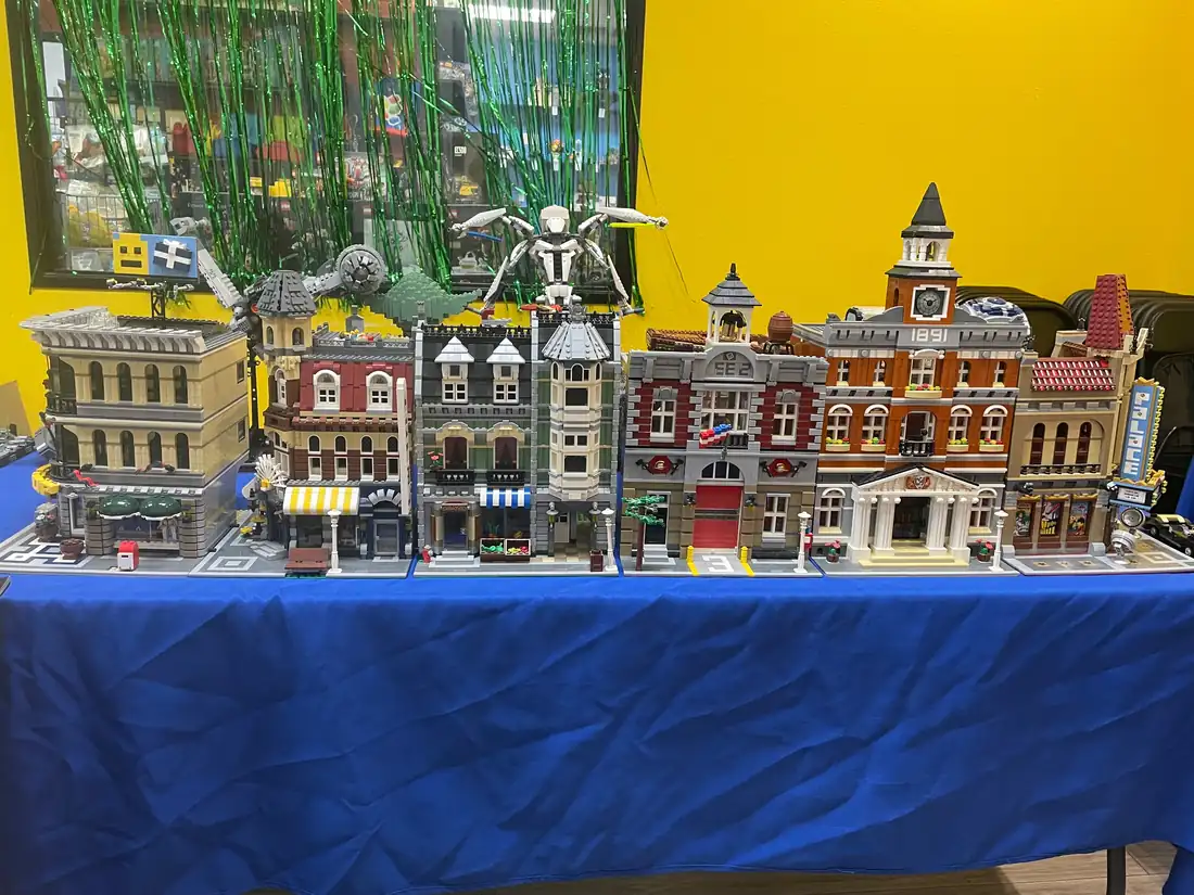 A row of LEGO® modular buildings displayed on a blue-covered table.