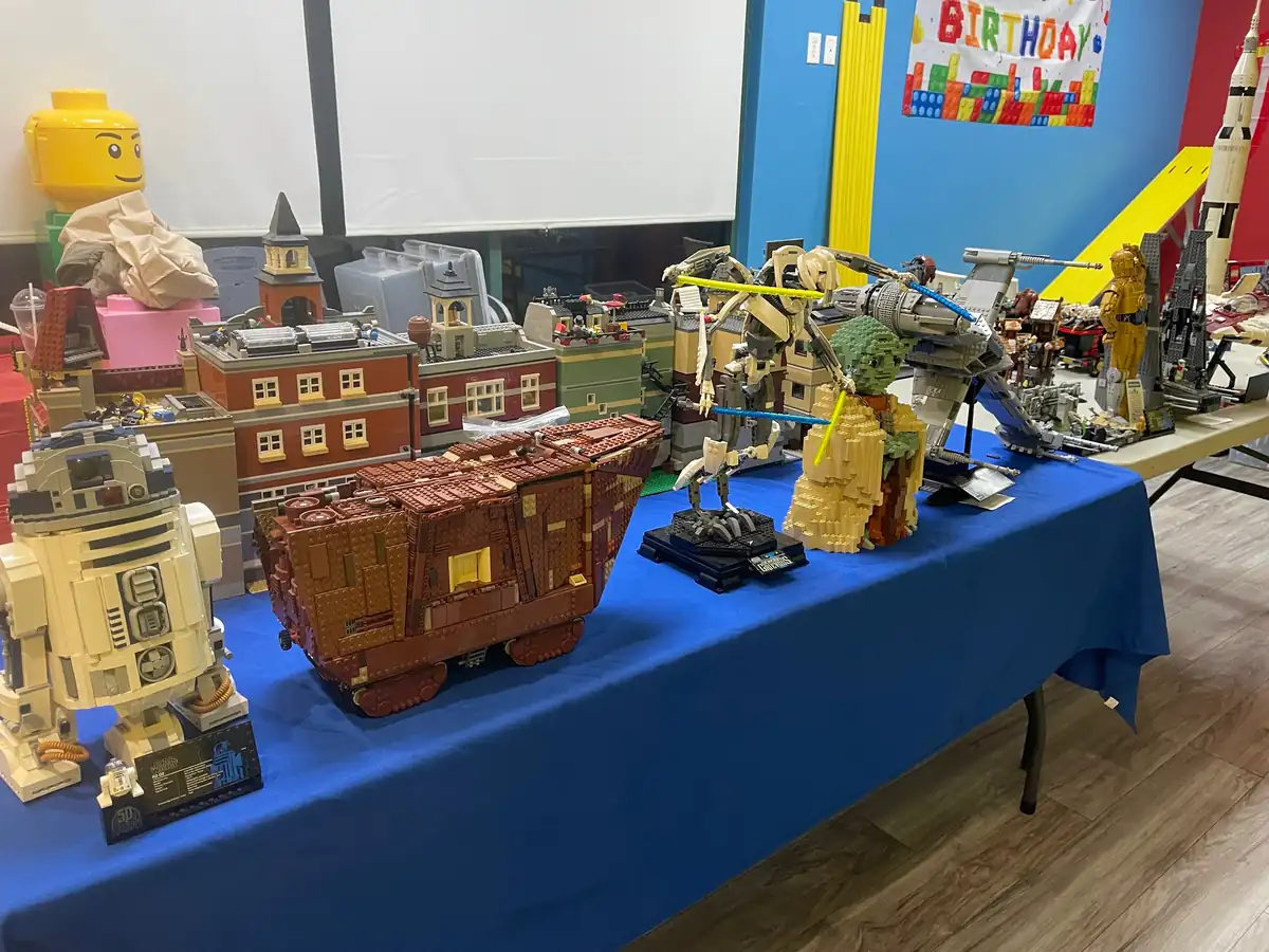 LEGO® ships, buildings and other assembled models on a blue-covered table.