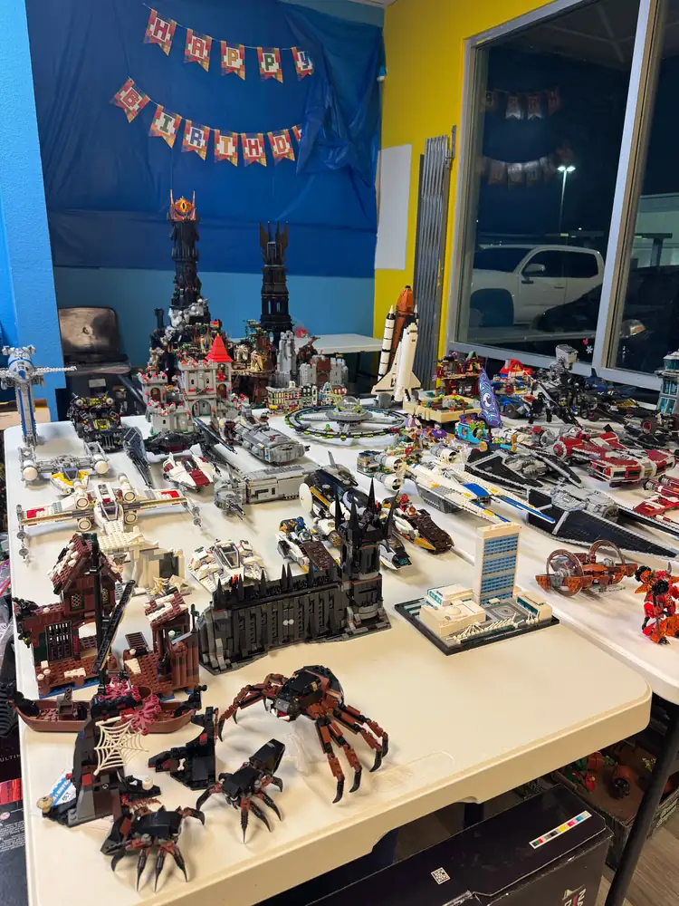 Assembled LEGO® models covering tables beside blue store walls.