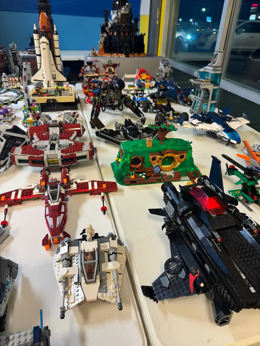 A wide assortment of assembled LEGO® vehicles and buildings on store tables.