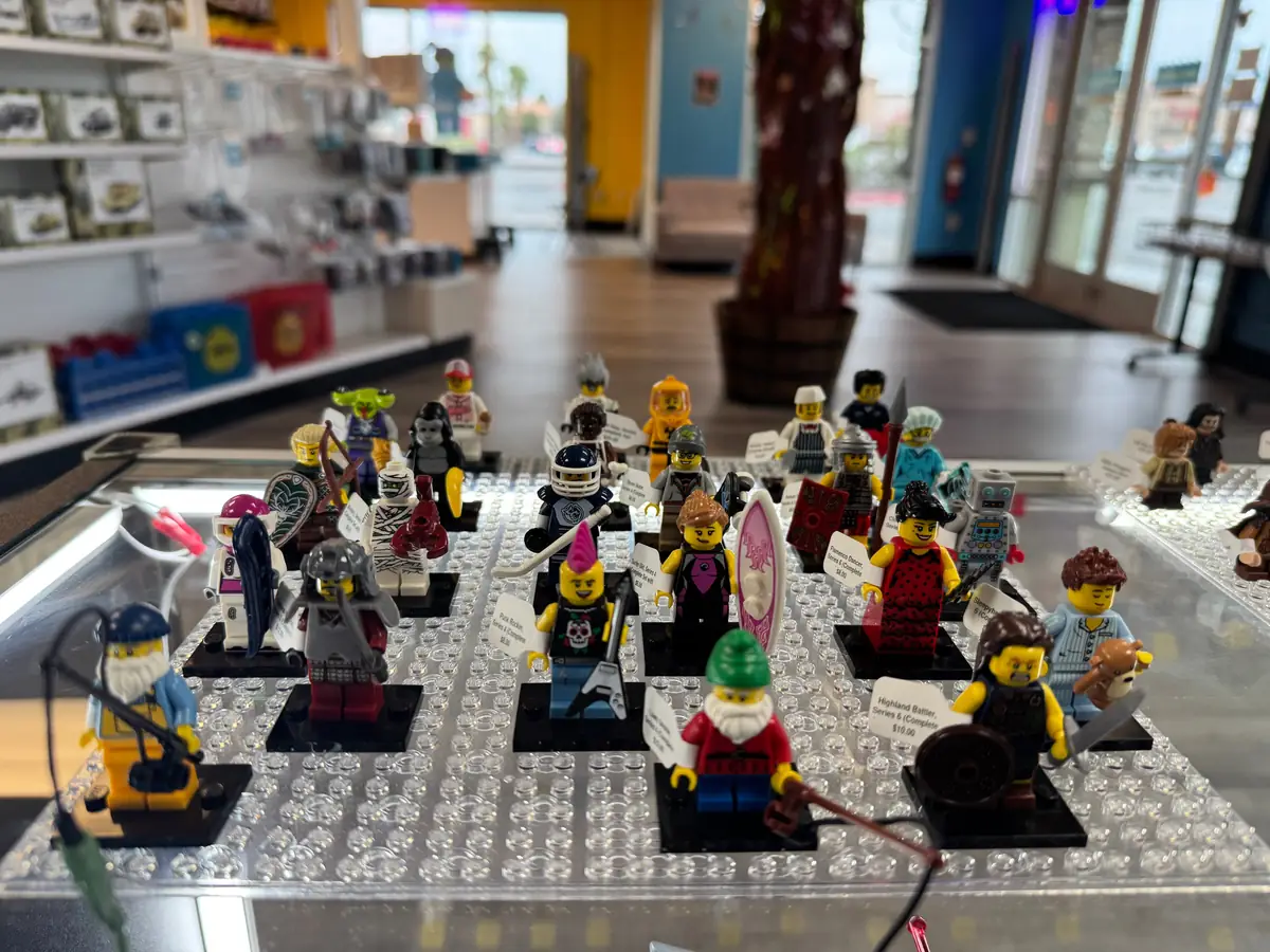 Rows of LEGO® minifigures on a hand-held display board at the Henderson store.