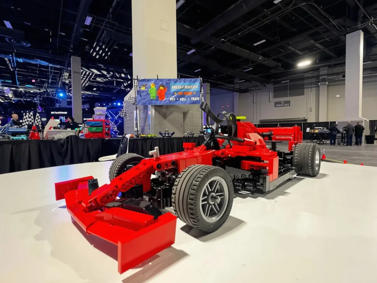 A red LEGO® race car displayed at a Bricks & Minifigs corporate event booth.